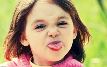 Девочка показывает язык