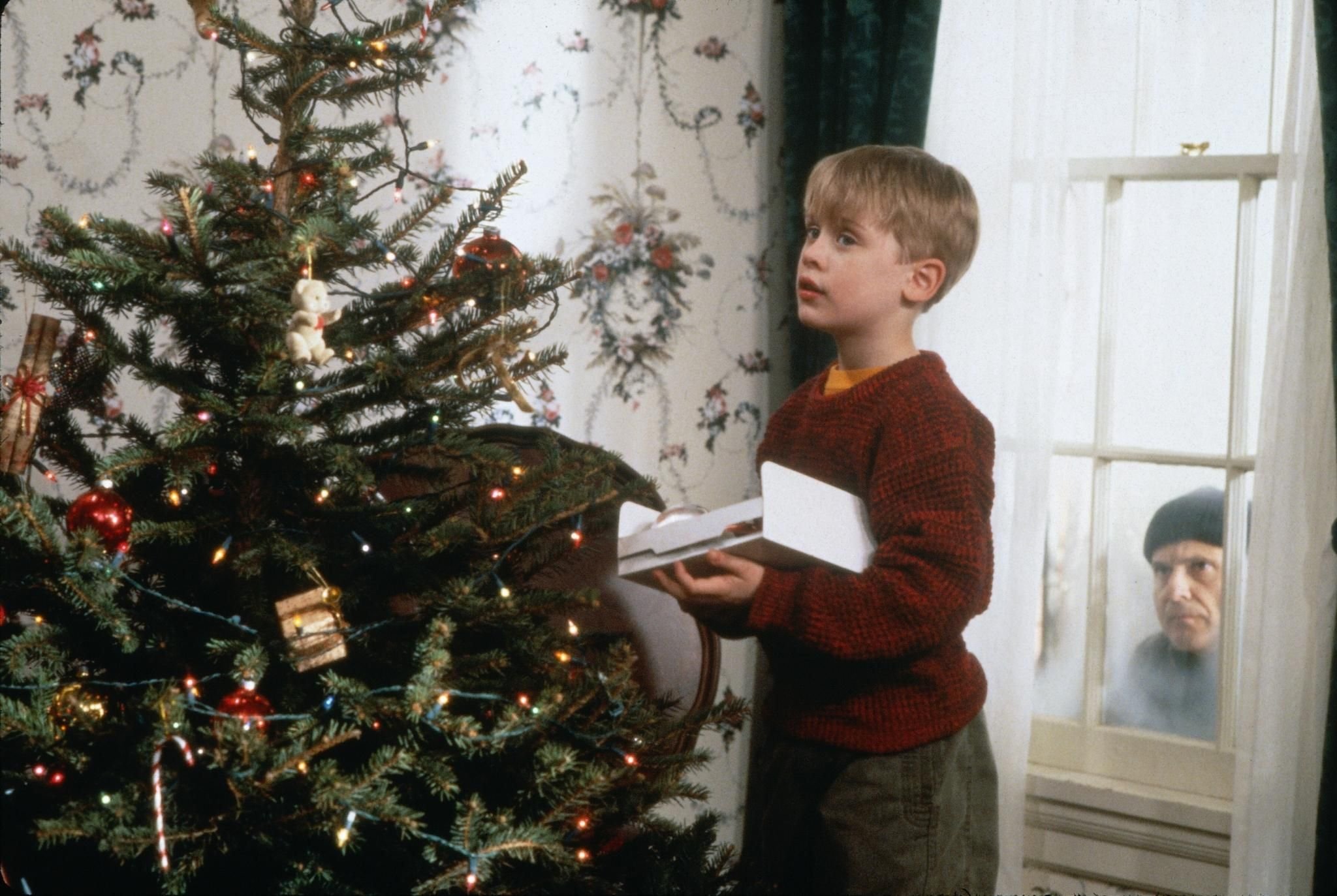 Кевин Маккалистер с елкой. Один дома Кевин наряжает елку. Маколей Калкин 1990. Кевин Маккалистер наряжает елку.