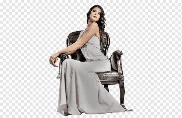 Девушка в платье сидит на стуле