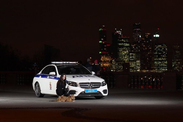 Девушка на фоне полицейской машины