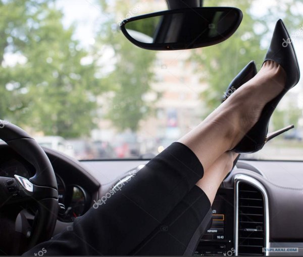 Женские ножки на торпеде автомобиля