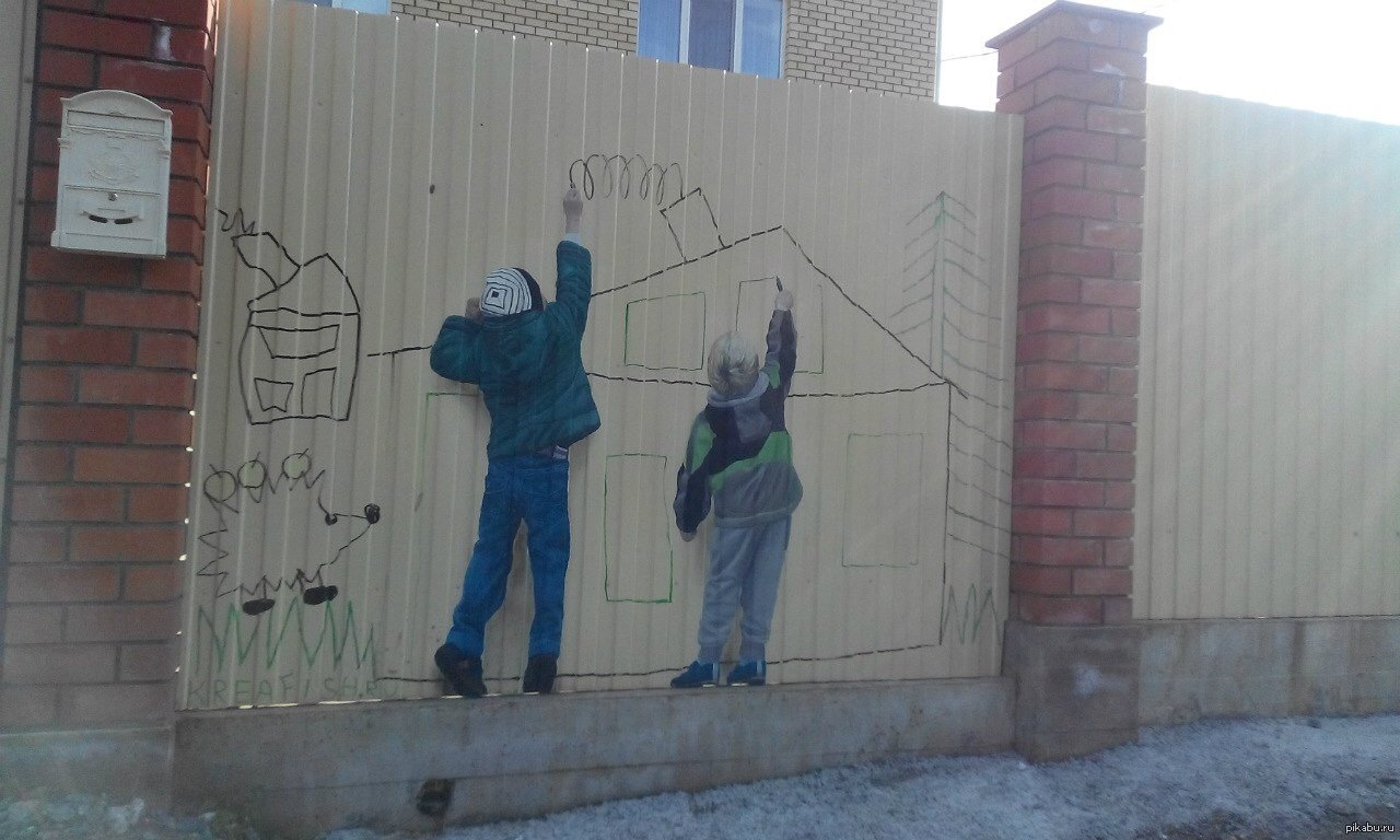 Дети рисуют на заборе