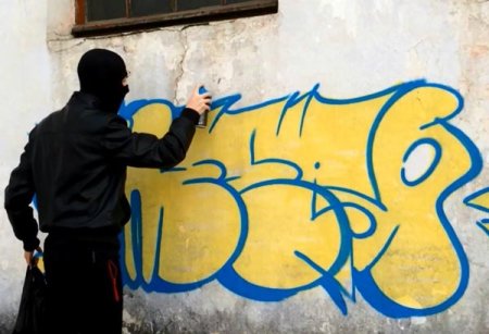 Пацан рисует граффити