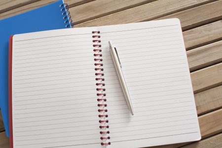 Открытый блокнот с ручкой